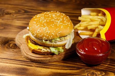 Delicious Big Hamburger With French Fries And Ketchup On Wooden Table