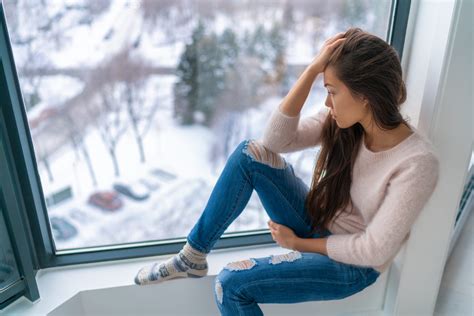 Winter Depressed Sad Girl Lonely By Home Window Looking At Cold Weather
