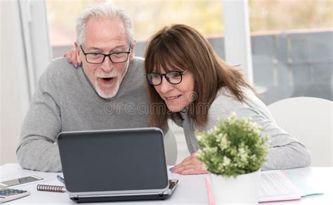 Happy Mature Couple Having A Good Surprise On Laptop Stock Image