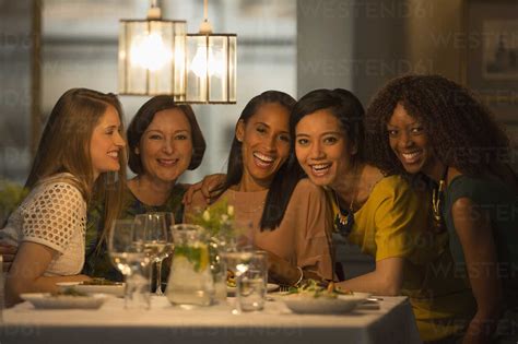 Portrait Smiling Women Friends Dining At Restaurant Table Stock Photo
