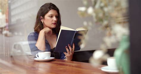 girl drinking coffee and reading book in cafe 1290144 stock video at vecteezy