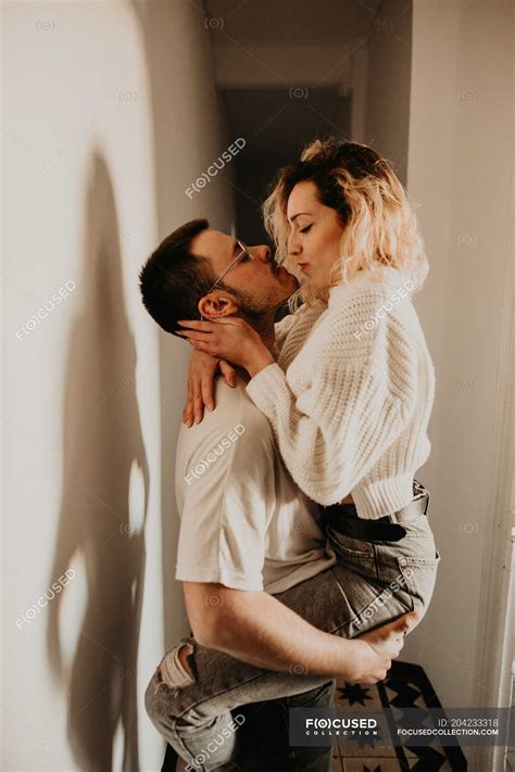 Passionate Man And Woman Embracing And Kissing At Wall At Home — Young