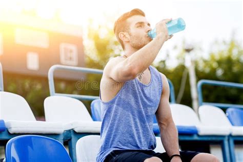 Sports Man Drinking Water After Exercising On Outdoors Stadium Stock
