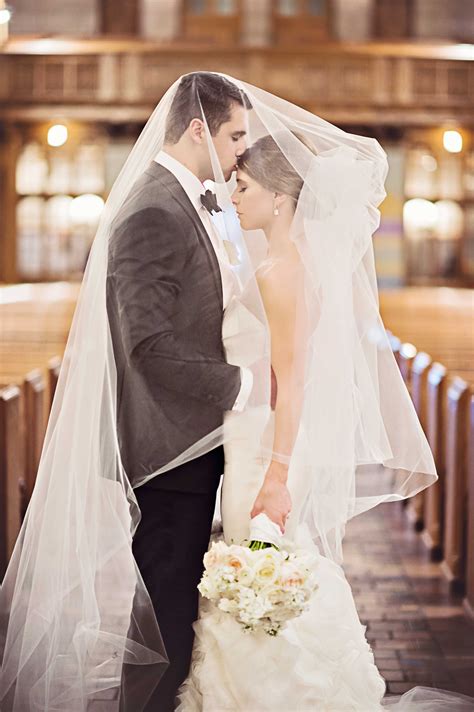 Bride And Groom Embrace Under Veil