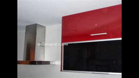 Cocina negra integrada en el salón. Muebles de cocina en color rojo granate con encimera de ...