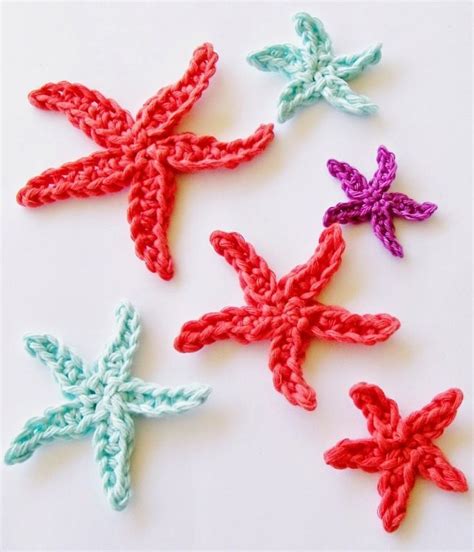 Four Crocheted Starfishs On A White Surface With Red Green And Blue