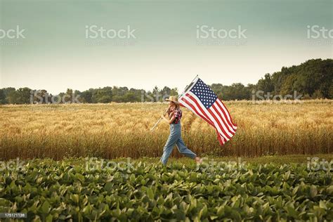 Farmer Girl Waving Usa Flag Marching Across Summer Farm Field Stock