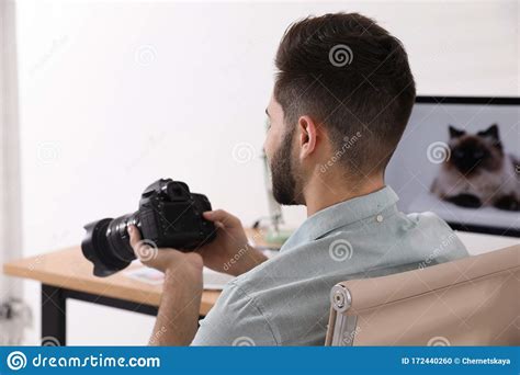 Professional Photographer With Camera Working At Table Stock Photo