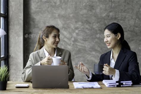 Two Young Beautiful Asian Business Woman In The Conversation