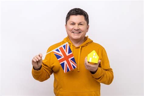 Premium Photo Delighted Man Holds British Flag And Paper House