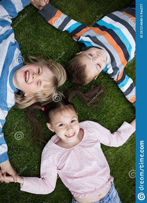 Feliz Dos Hermanos Y Hermanas Yacen En El Pasto Con Un Sentimiento De Felicidad Y Unidad Foto