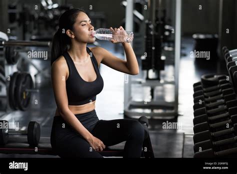 Asian Young Woman Drink Water After Breaking From Dumbbell Workout Or