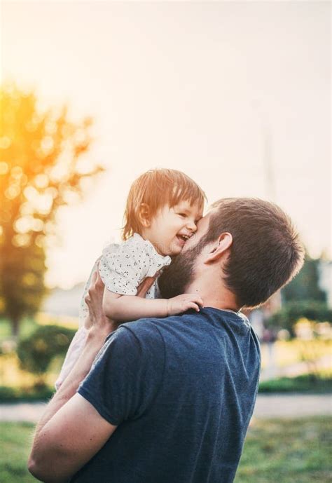 Little Daughter In Her Father S Arms Smiling And Hugging Dad In A