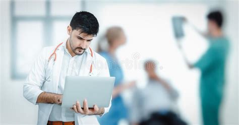 Male Medical Doctor Is Using Laptop For Examining Patient In