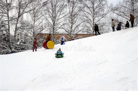 Children And Adults Having Fun On A Snow Hill Editorial Photography