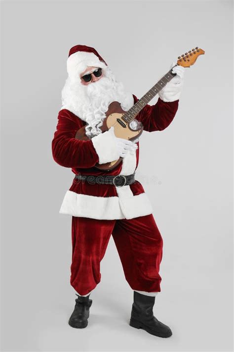 Santa Claus Playing Electric Guitar On Light Grey Background Christmas
