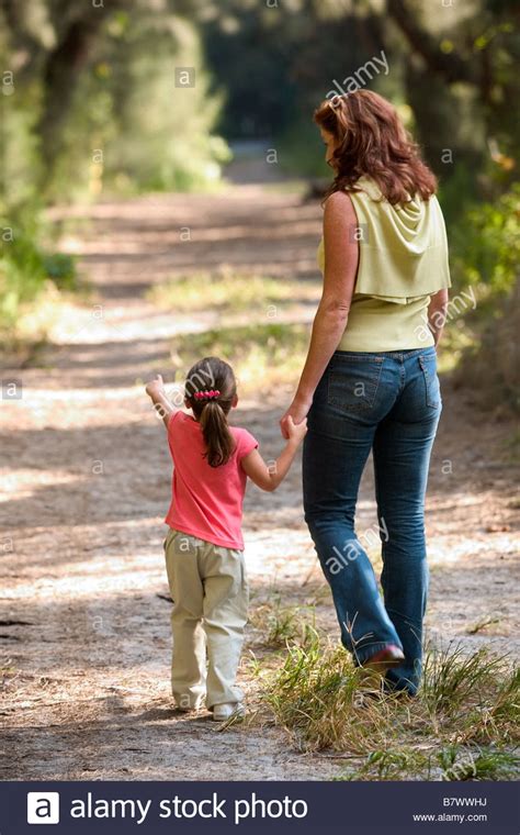 Mother And Child Walking In Park On Trail Stock Photo
