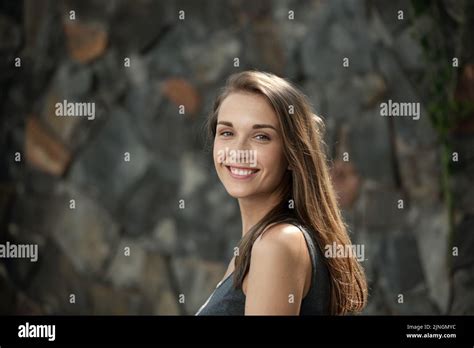 Portrait Of Naturally Beautiful Girl Smiling At Camera On Stone