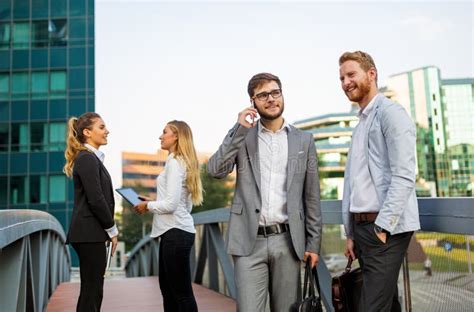 Group Of Cheerful Young Business People Talking To Each Other While