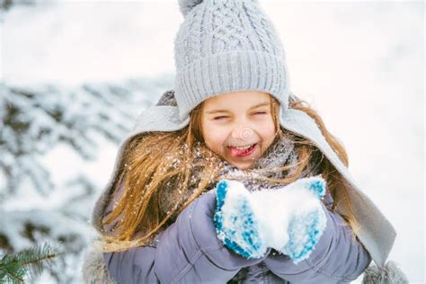Little Girl Smiling And Playing In Winter With Snow Stock Photo