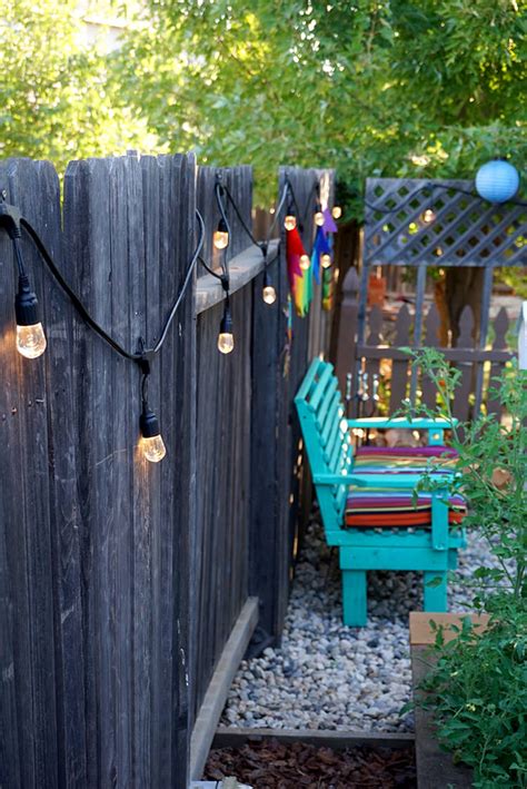 Lay your string lights out along the fence where you want to hang them. Colorful Outdoor Entertaining Area - Happiness is Homemade