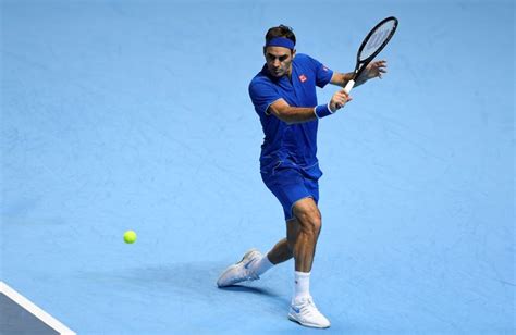 A Man Swinging A Tennis Racquet At A Ball On A Blue Tennis Court