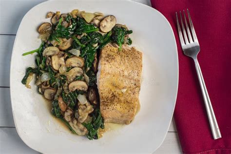 Baked Season Salmon With A Side Of Sauteed Spinach And Mushrooms Stock