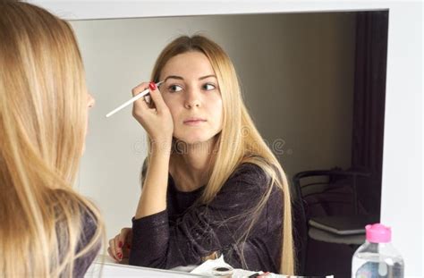 Reflection Of Young Beautiful Woman Applying Her Make Up Stock Image