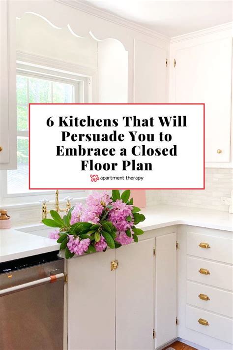 A Kitchen With White Cabinets And Pink Flowers On The Counter Top Text