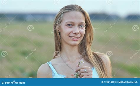 Portrait Of A Young Smiling Sixteen Year Old Girl With A Daisy Flower