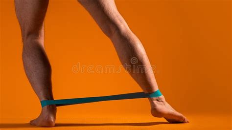 Muscular Men`s Legs With Elastic Band For Fitness Do Exercises To