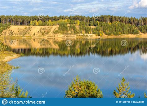 Emerald Lake With Textural Clouds Sandy Mountains And Forest View