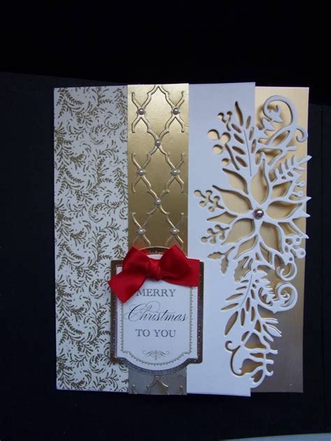A Christmas Card With A Red Bow On The Front And Gold Foilwork On The Back