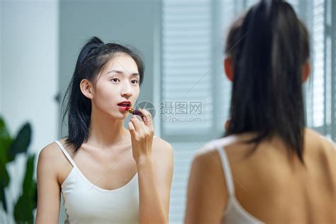 漂亮的年轻女人照着镜子涂口红高清图片下载 正版图片507646895 摄图网