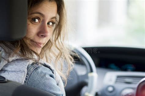 Girl Driving Car Young Woman Behind Driver`s Seat Looking At Car`s Rear Seat Stock Image