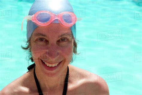 Caucasian Woman In Goggles And Swim Cap By Swimming Pool Stock Photo
