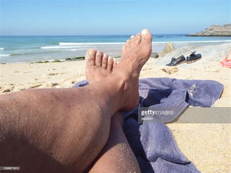 A Man Lying On The Sand Enjoying A Day At The Beach Photo Getty Images