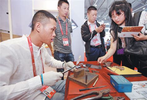 visitors watch a demonstration of wuhu iron painting at an exhibition