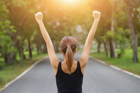 Successful Woman Raising Arms After Cross Track Running On Summer