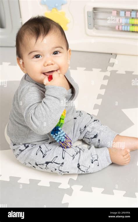Six Month Old Baby Boy Sitting On Floor Smiling Portrait Looking At