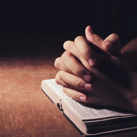Orando Con Las Manos Con La Biblia Fotografía De Stock © Christianchan