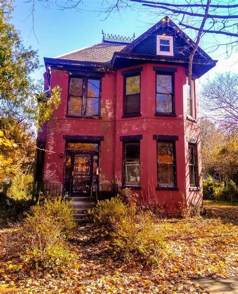 An Old Red House In The Fall With Leaves On The Ground