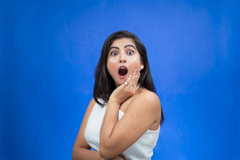 Surprised And Amazed Girl Hold Her Cheek And Looks To The Front With Blue Background Pixahive