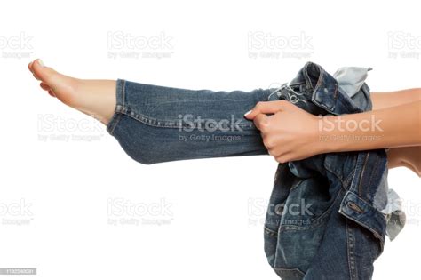 Young Woman Trying To Put On Her Tihgt Jeans On White Background Stock