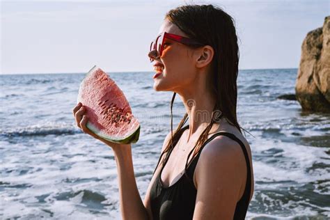 Cheerful Woman In Black Swimsuit Eating Watermelon On The Beach Stock