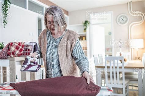 A Mature Older Woman Ironing Clothes Home Chores A Portrait Of An