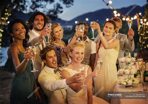 Wedding Guests Toasting With Champagne During Wedding Reception In