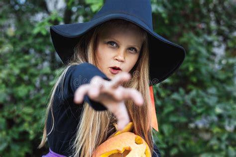 Little Girl In Witch Costume Having Fun On Halloween Trick Or Treat