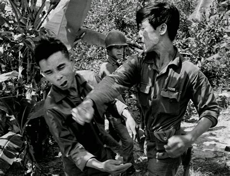 South Vietnamese Soldier Punches The Face Of A Suspected Viet Cong Guerrilla During An