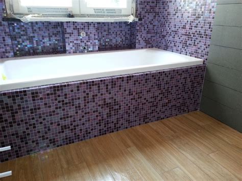 Le piccole piastrelle a mosaico aiuteranno ad aggiungere un tocco di colore al bagno o forniranno il focus principale nel design. Rivestimento della vasca da bagno in mosaico di vetro viola